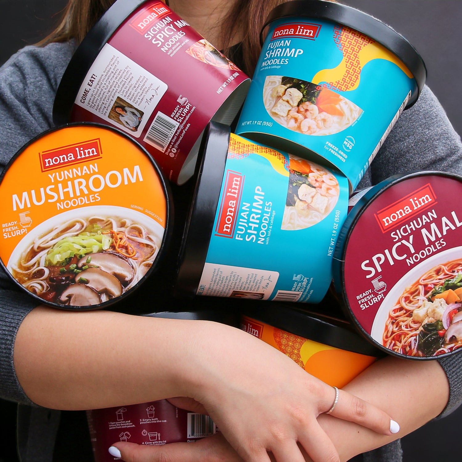 Person holding lots of Nona Lim Instant Noodle Bowls
